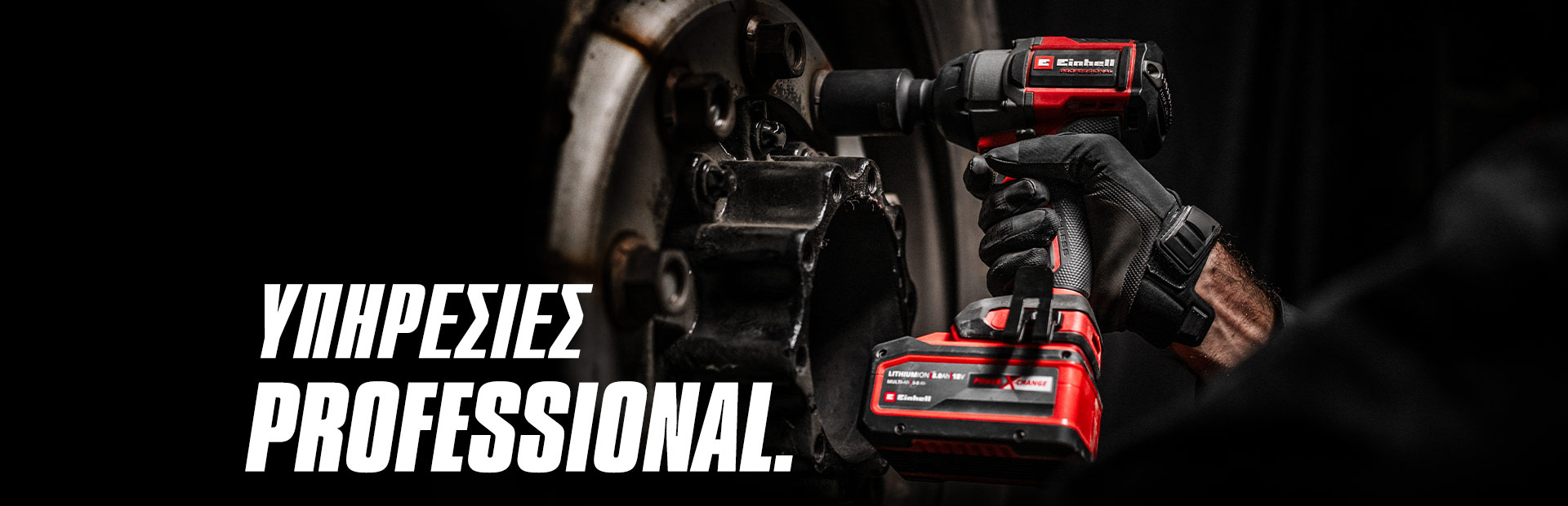 Κοντινό πλάνο κόκκινου κρουστικού κλειδιού μπαταρίας που χρησιμοποιείται σε τροχό, με το κείμενο "Επαγγελματικές Υπηρεσίες".