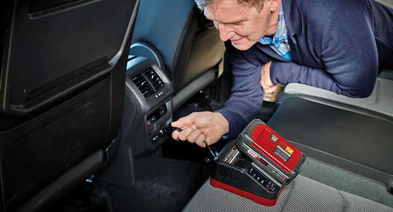 man using a battery charger in the car